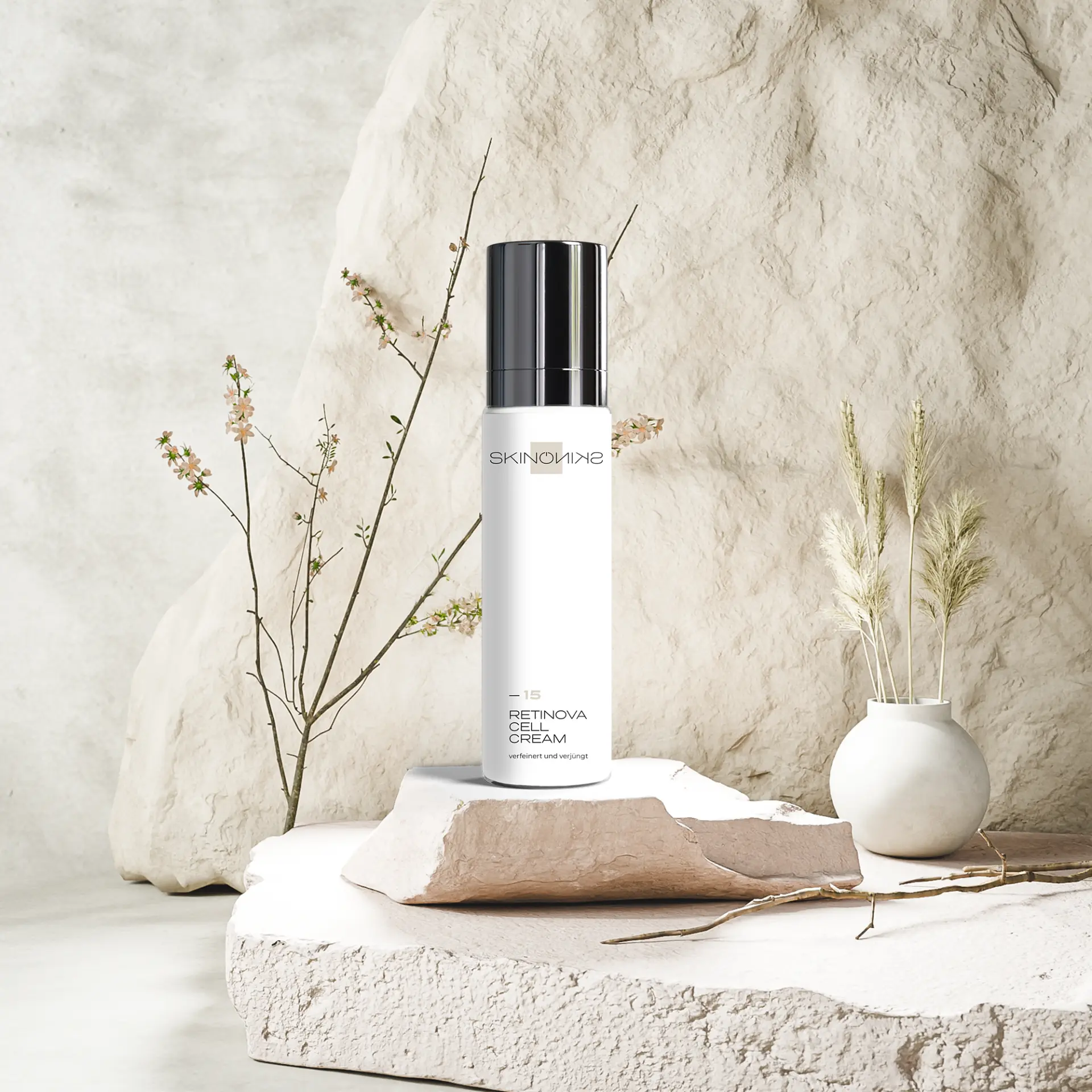 SKINONSKIN Retinova Cell Cream auf hellem Stein mit Blütenzweig