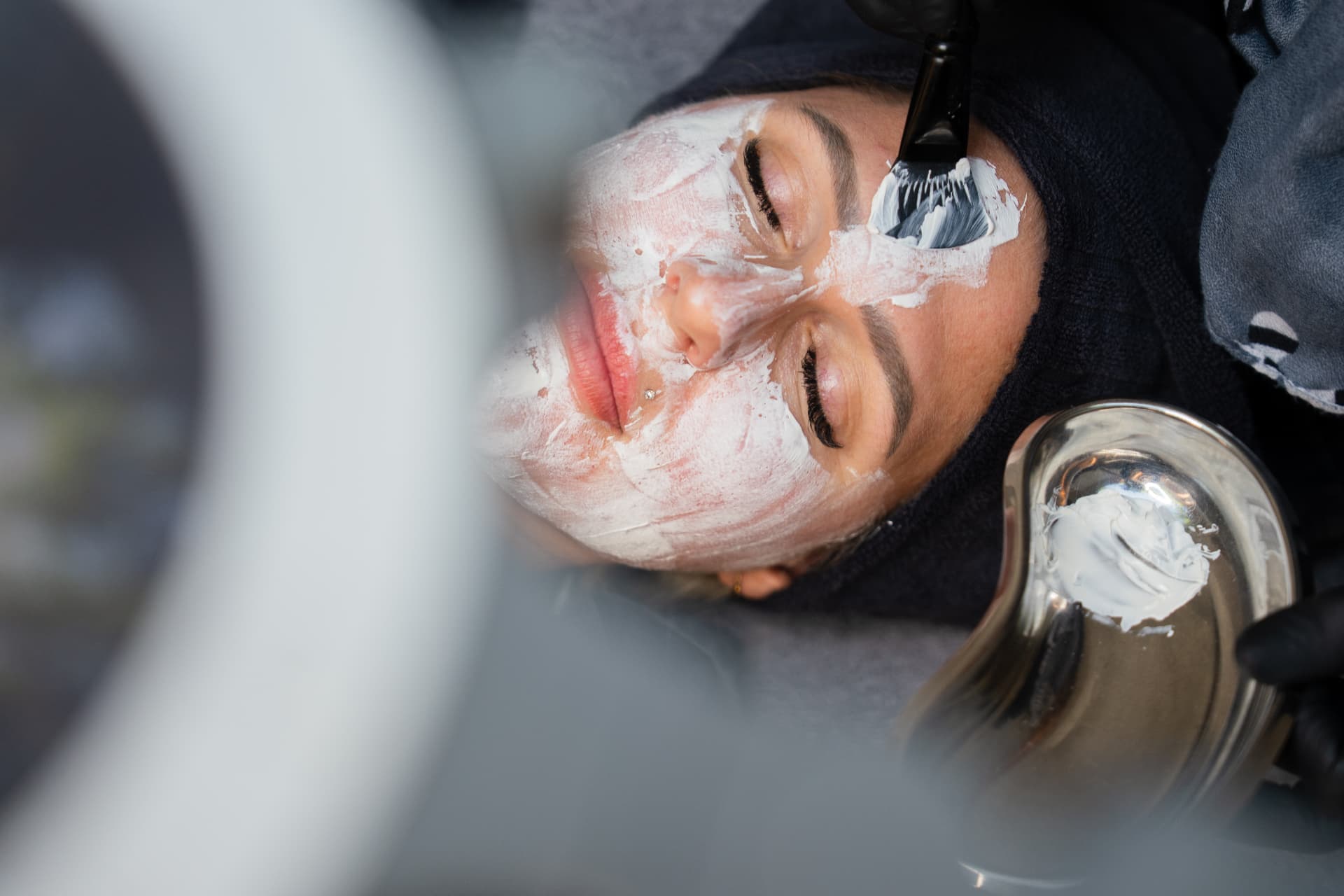 Kundin mit geschlossenen Augen bei einer Maskenbehandlung
