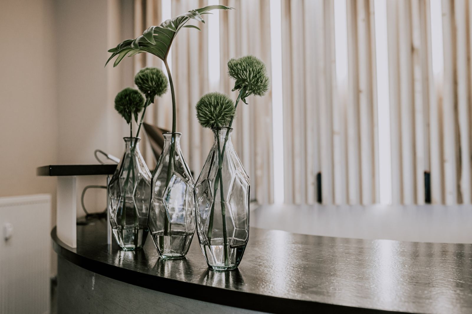 Glasvasen mit grünen Blüten auf der Theke