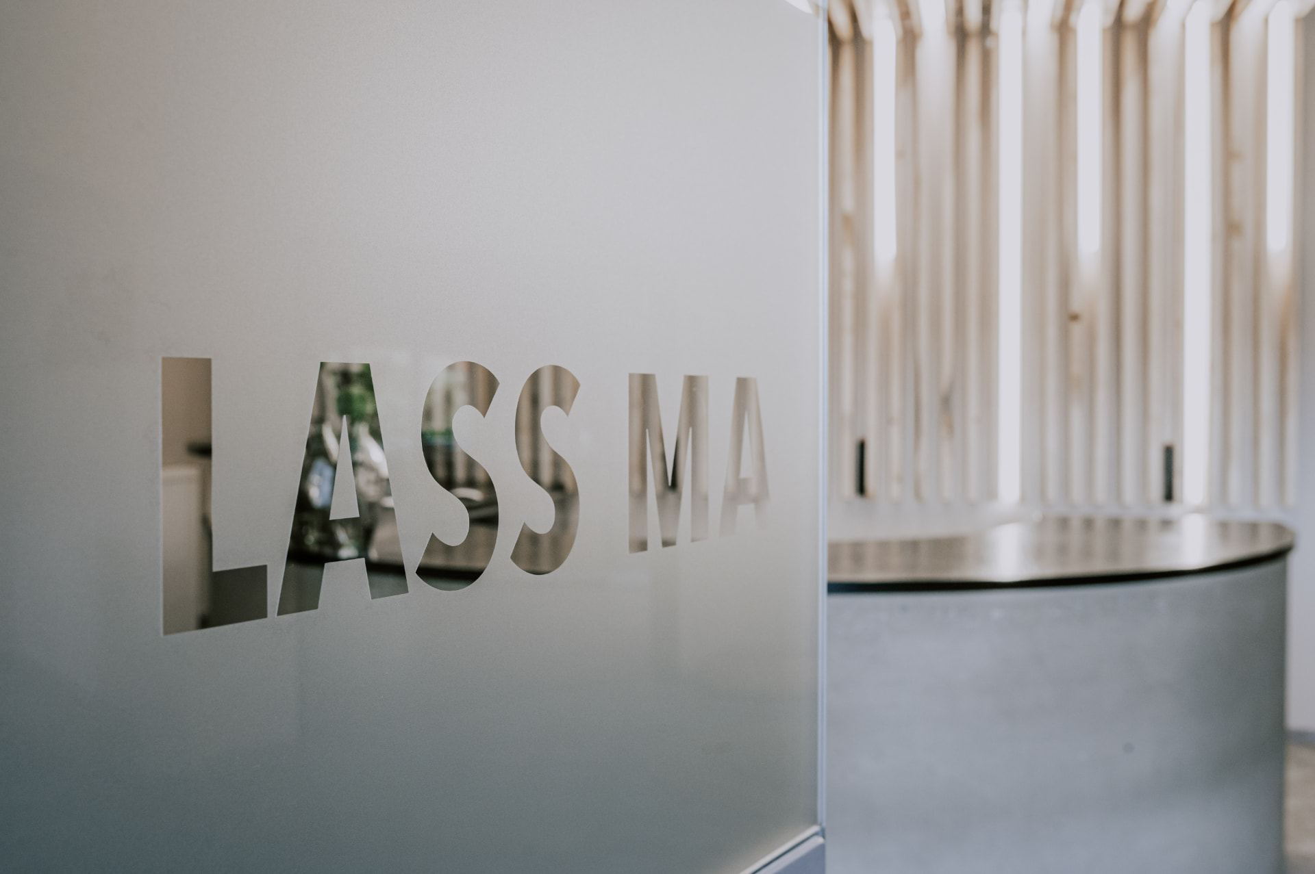 Helle Lounge am Empfang mit dem Schriftzug „Lass ma“